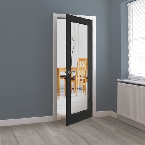 Black-framed glass door in a room with gray walls and a window.