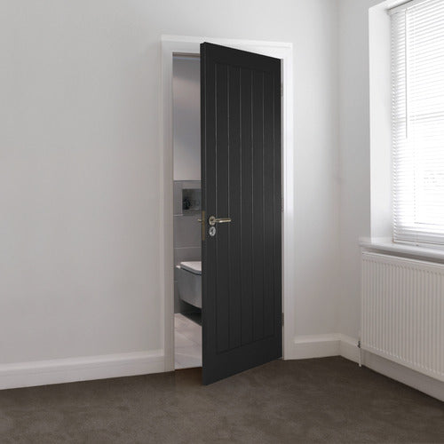 Black door open in a room with a window and radiator.