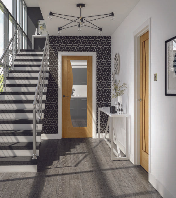 Modern interior with a staircase, black and white patterned wall, and wooden door.