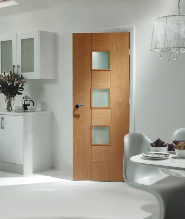 Wooden interior door with glass panels in a modern room setting.