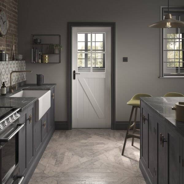 Modern kitchen with dark gray cabinets, white door, and light-colored floor.