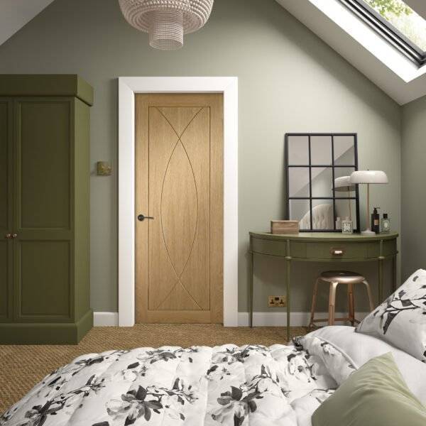 Bedroom interior with wooden door, green wall, and floral bedspread.