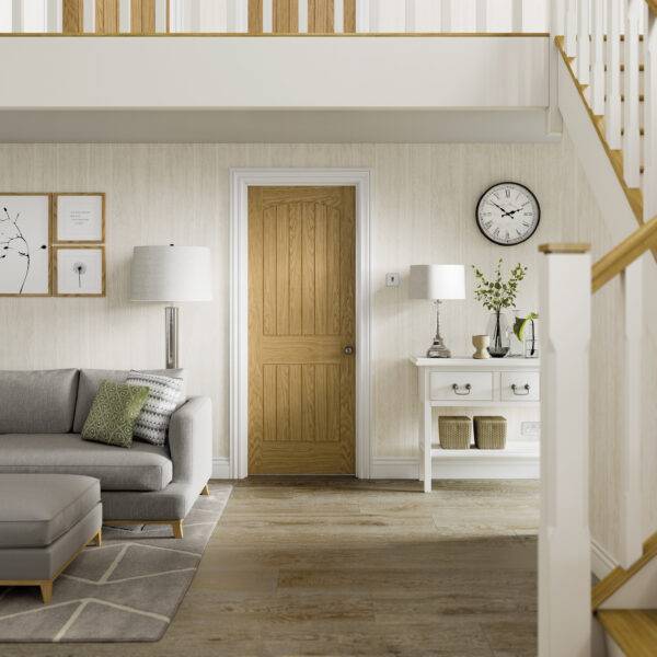 Living room with gray sofa, wooden door, and staircase