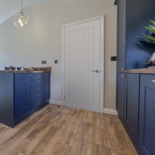 Modern kitchen with blue cabinets and wooden flooring