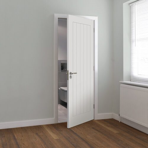 Open white door leading to a bathroom in a room with wooden flooring and a window.