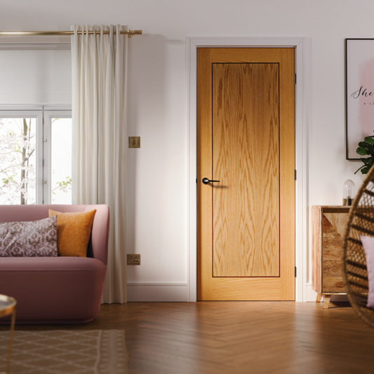 Wooden door in a room with a pink sofa and a window.