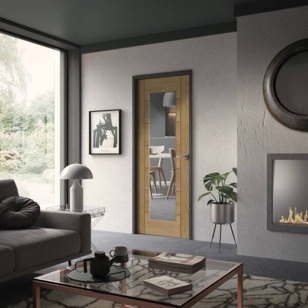 Modern living room with a glass door, sofa, coffee table, and decorative elements.