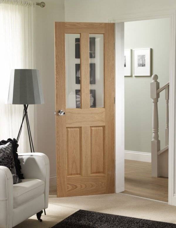 Wooden door with glass panels in a room with a white armchair and lamp.