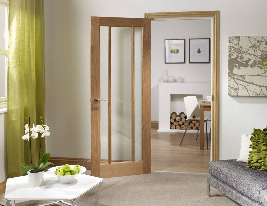 Wooden interior door with glass panels in a living room setting.