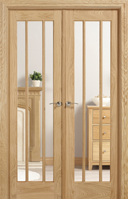 Wooden interior doors with glass panels in a room setting.