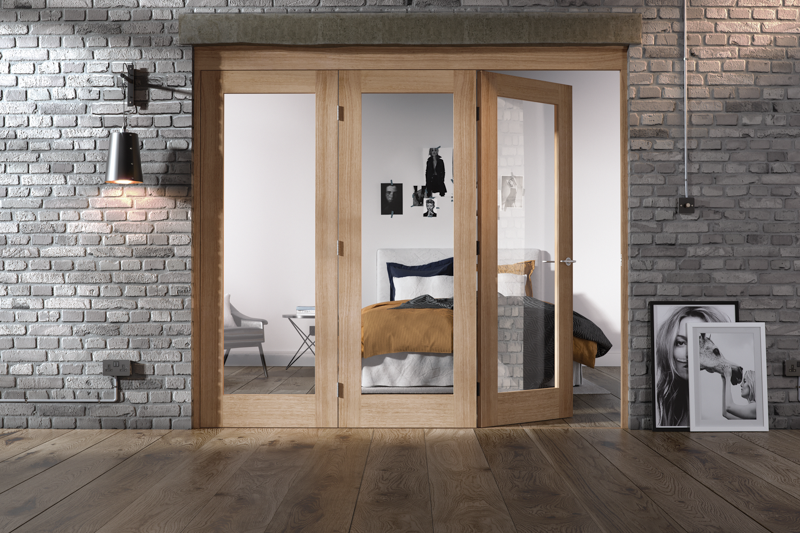 Wooden sliding doors in a room with brick walls and a bed visible through the glass.