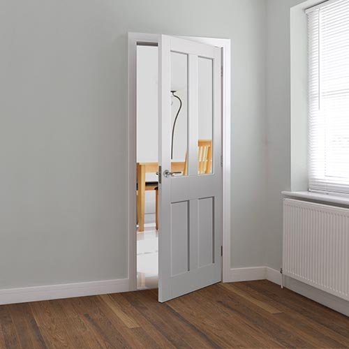 White door with glass panel open in a room with wooden floor and window.