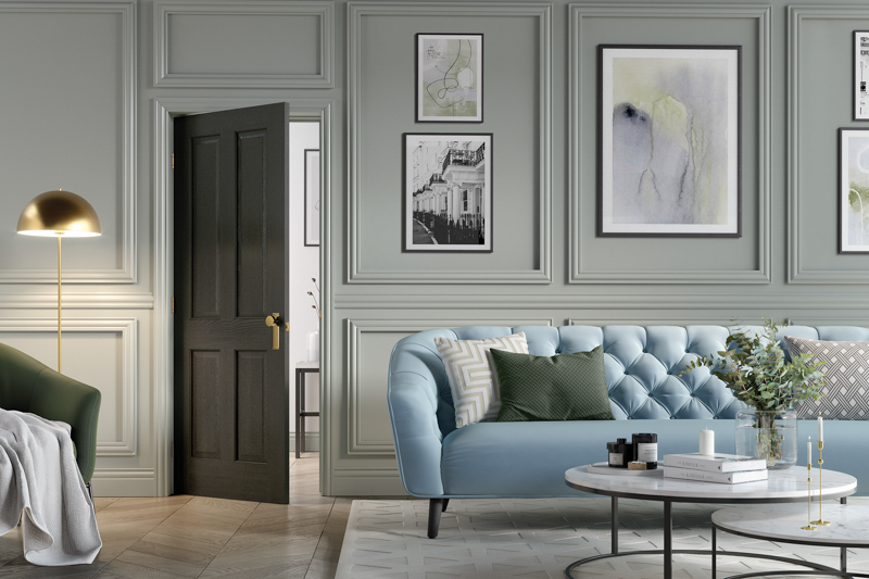 Modern living room with a blue sofa, dark toned door, coffee table, and decorative elements.