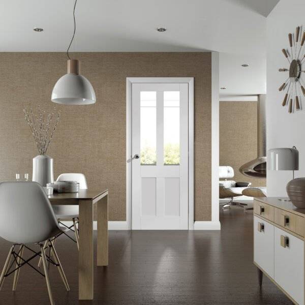 Modern interior with a white door, dining table, and kitchen area.