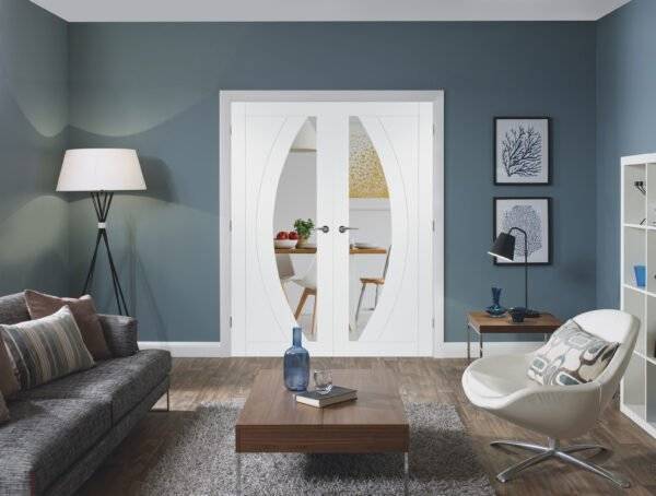 Modern living room with gray sofa, coffee table, and white armchair.