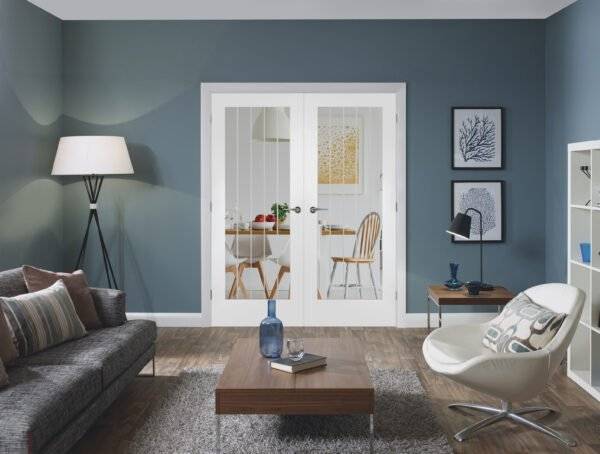 Modern living room with gray sofa, wooden coffee table, and white armchair.