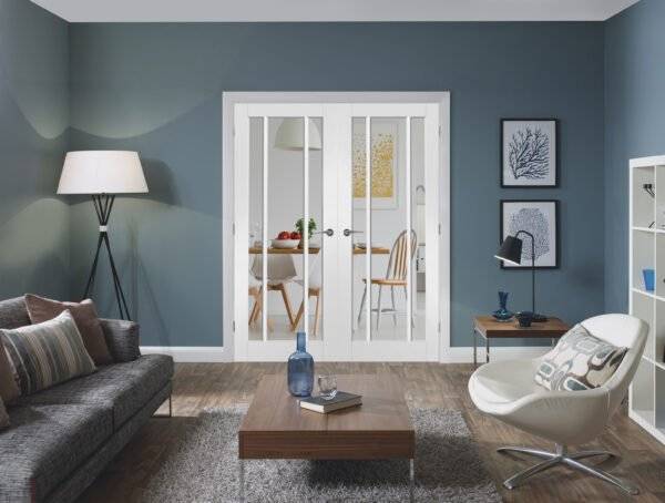 Modern living room with gray sofa, white armchair, and wooden coffee table.