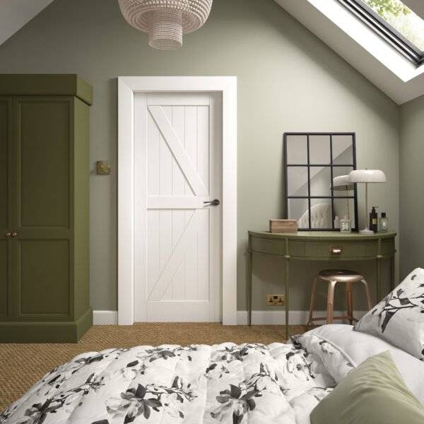 Bedroom interior with a bed, desk, and door.