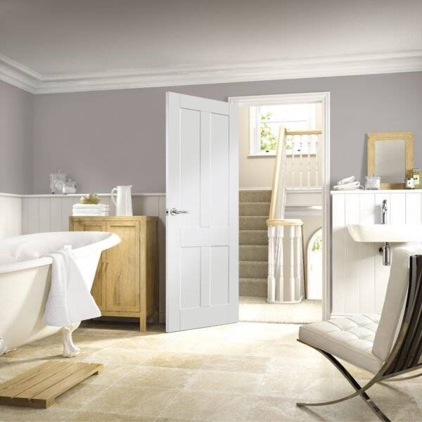 Modern bathroom with freestanding bathtub, wooden cabinet, and white door.