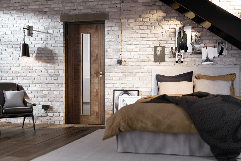 Modern bedroom with brick wall, walnut wood door, and bed with brown and gray bedding.