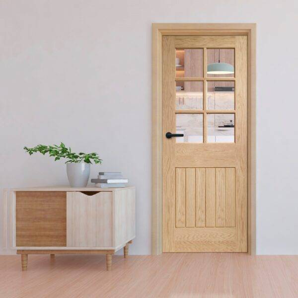Wooden door with glass panels in a room with a sideboard and plant.