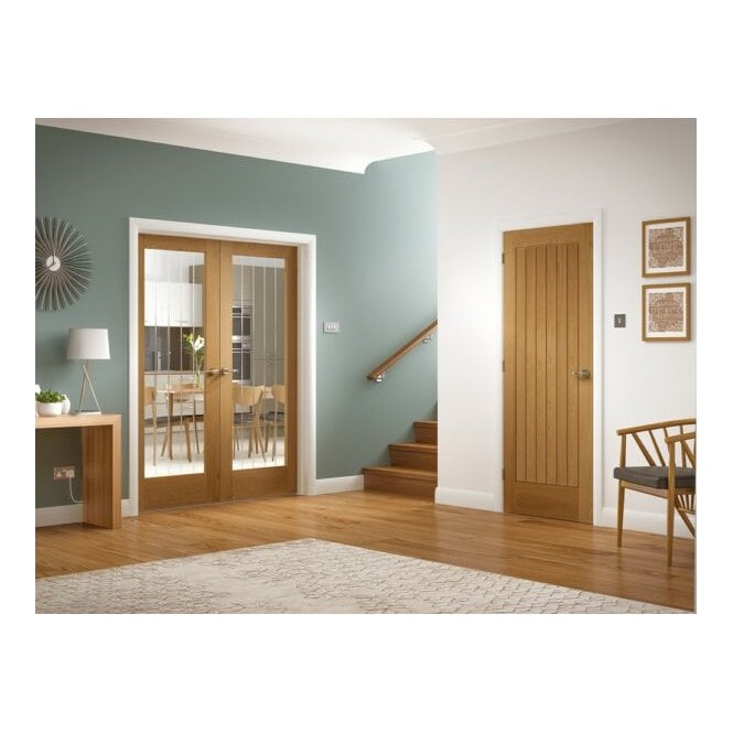 Two wooden doors in a home interior setting with one open to a dining area.